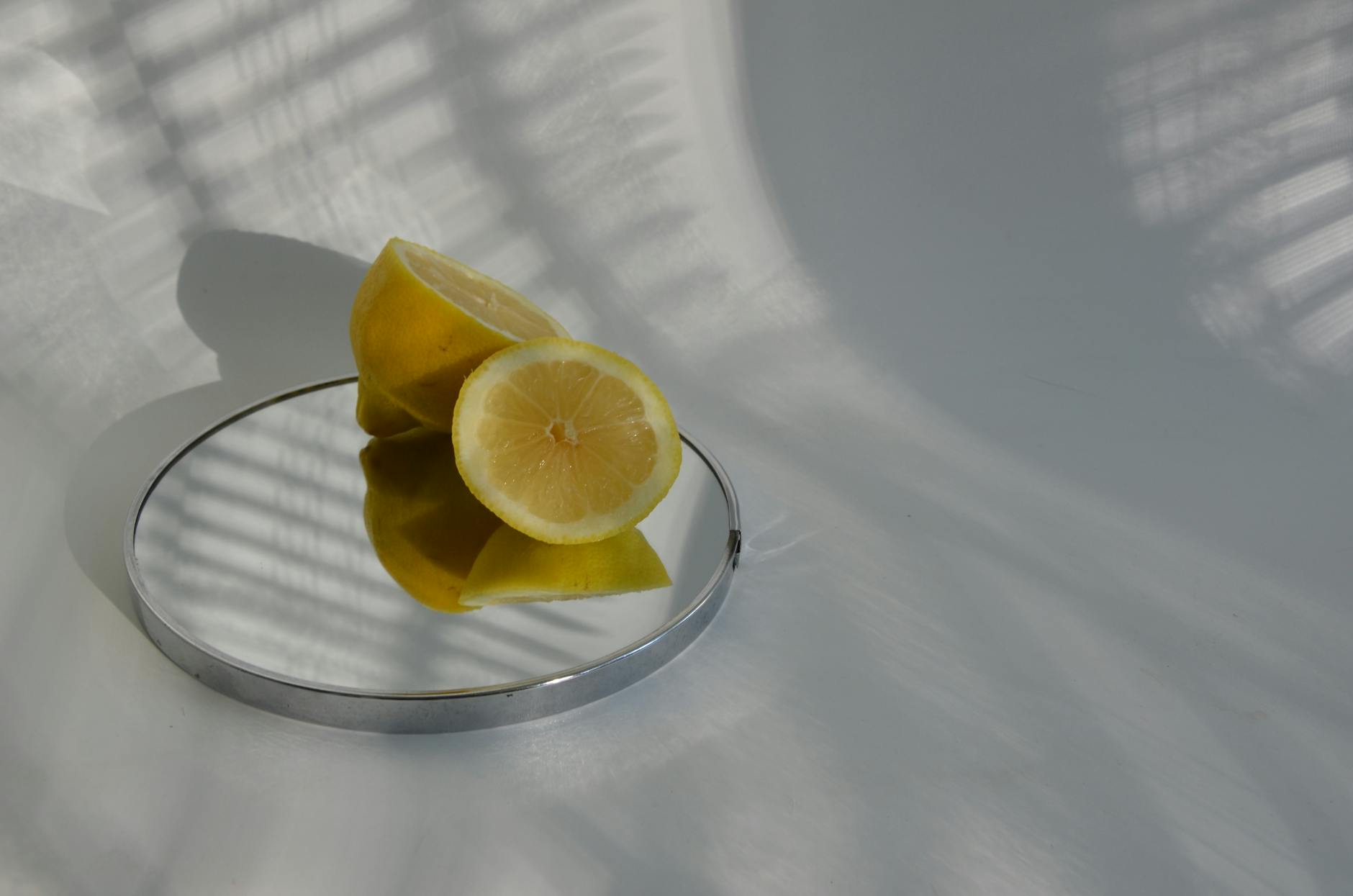 Hand holding a blue lemon clitoral vibrator above a decorative glass bowl